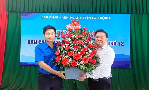 Đồng chí Nguyễn Văn Hồng, Uỷ viên BTV, Trưởng Ban Tổ chức Huyện uỷ tặng hoa chúc mừng đồng chí Chu Quang Khanh.